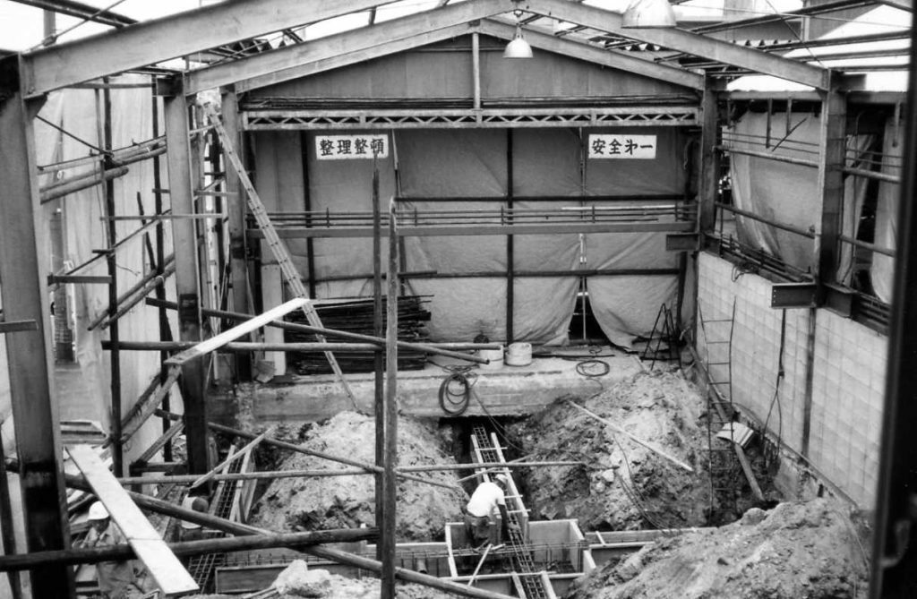 鉄柱を据えて屋根を建設している当時の工事風景